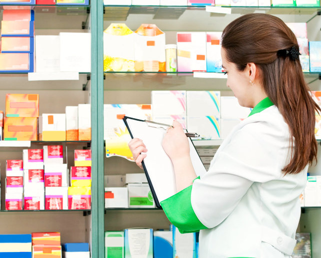 female pharmacist checking medicines in the shelves